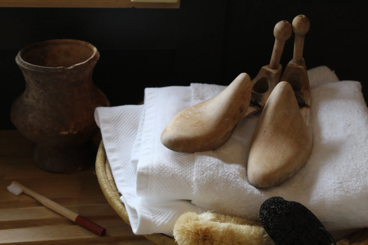 Wooden shoe forms on a white cloth with a dark background
