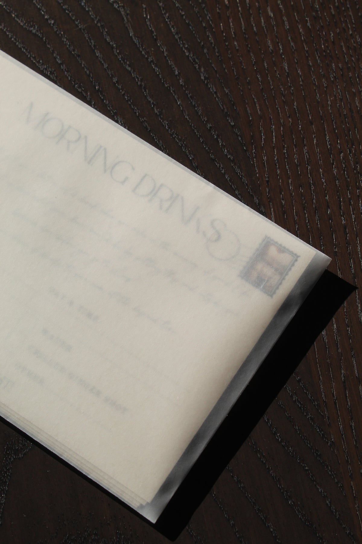 Cards in velum envelope on dark wood background