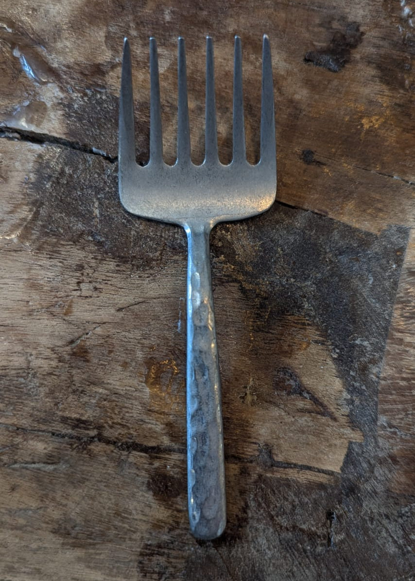 Metallic fork on a wooden surface