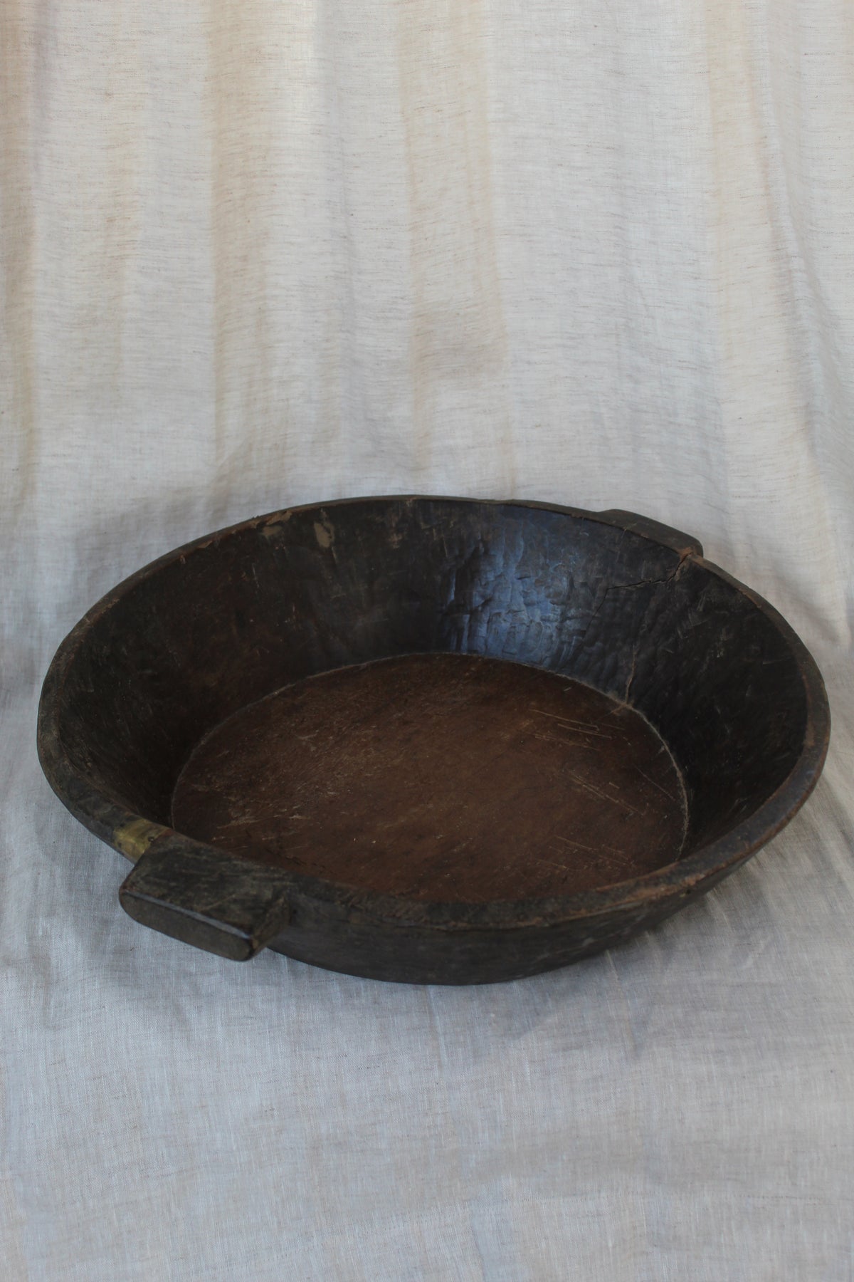Wooden bowl on a light fabric background
