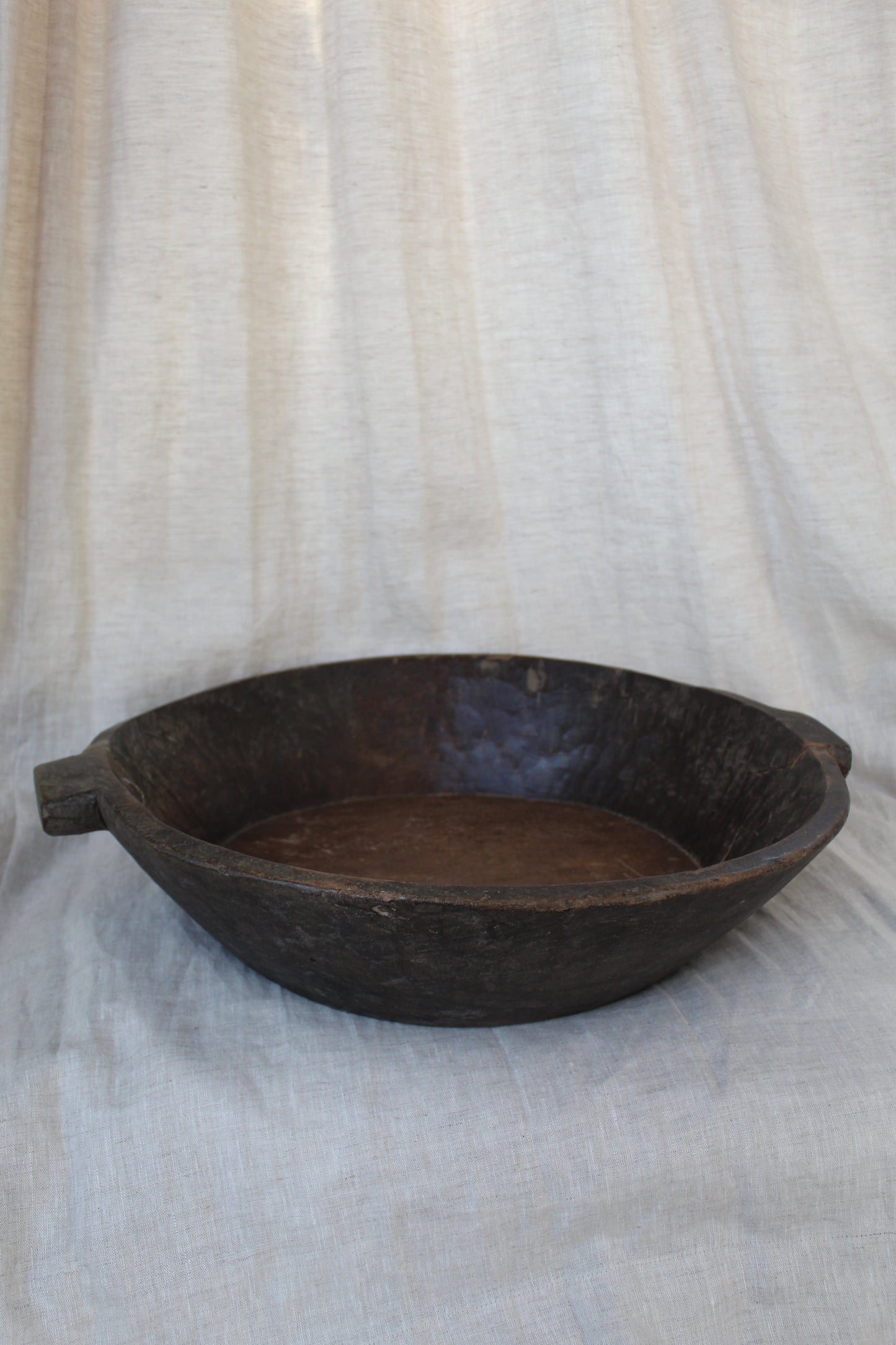 Brown wood bowl on a textured white surface