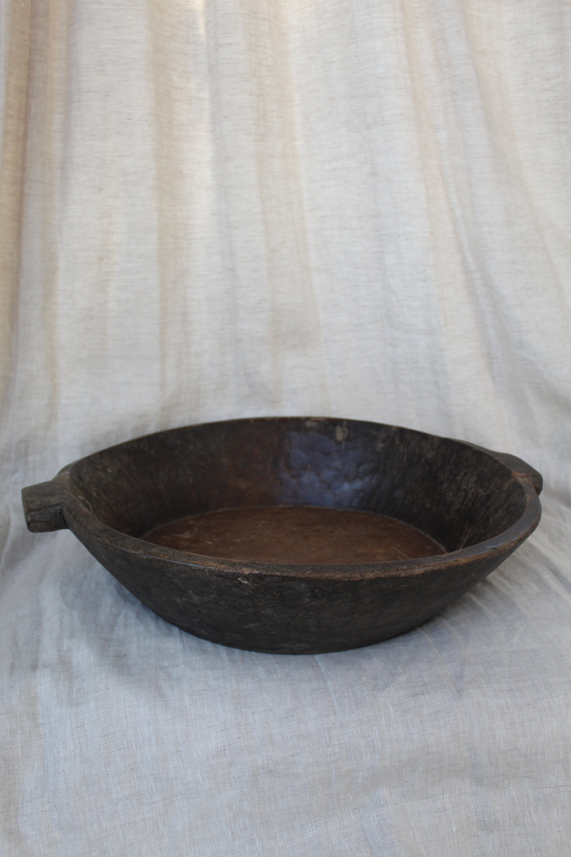 Brown wood bowl on a textured white surface