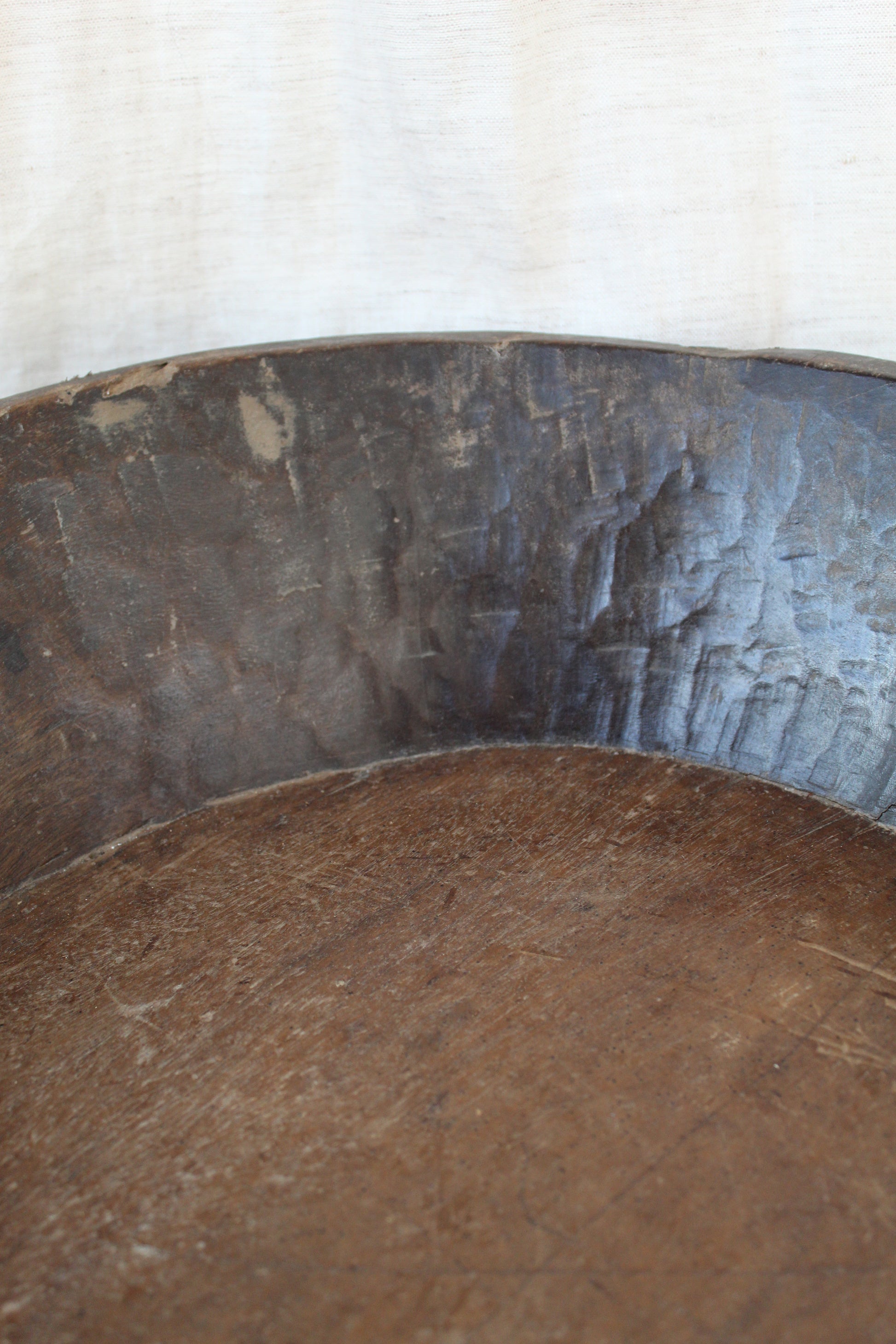 Close-up of a wooden bowl and material details on a white background
