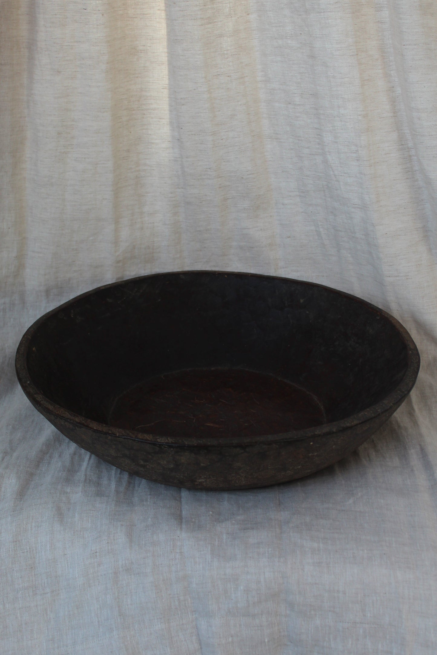 Dark brown oval object on a striped fabric background