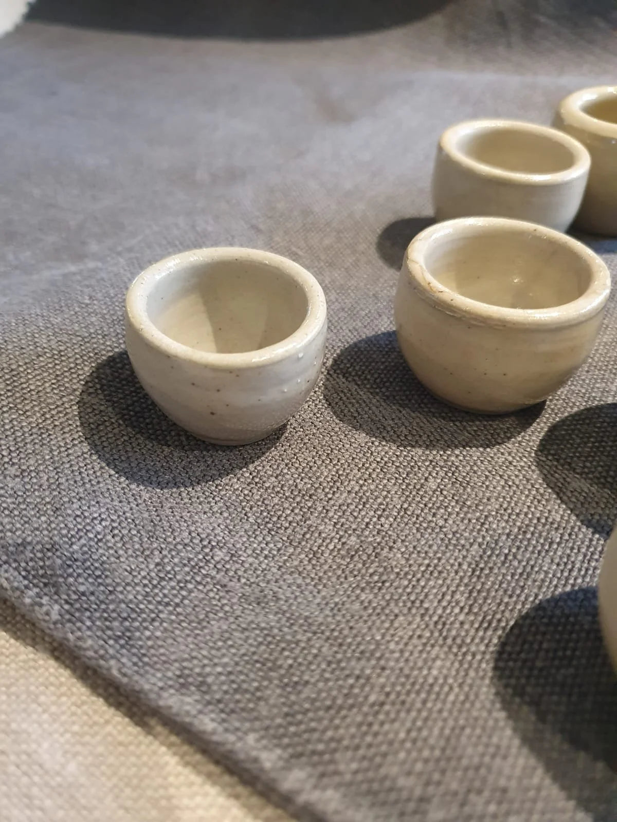 Set of small ceramic cups on a textured surface