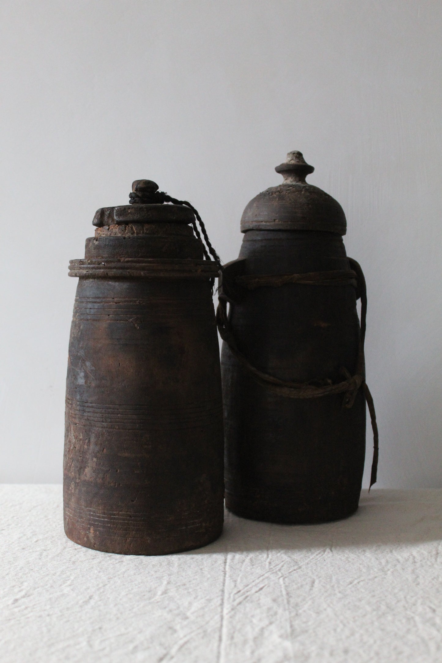 Two old wooden canisters with metal lids on a white background