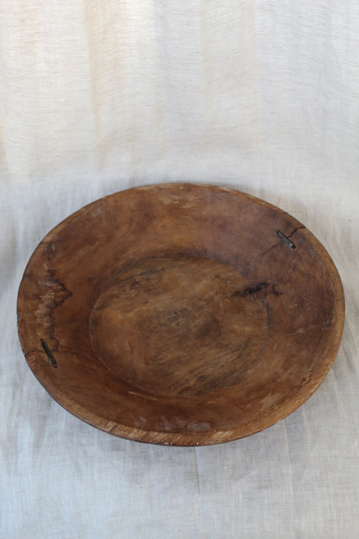 Wooden bowl on a light fabric background