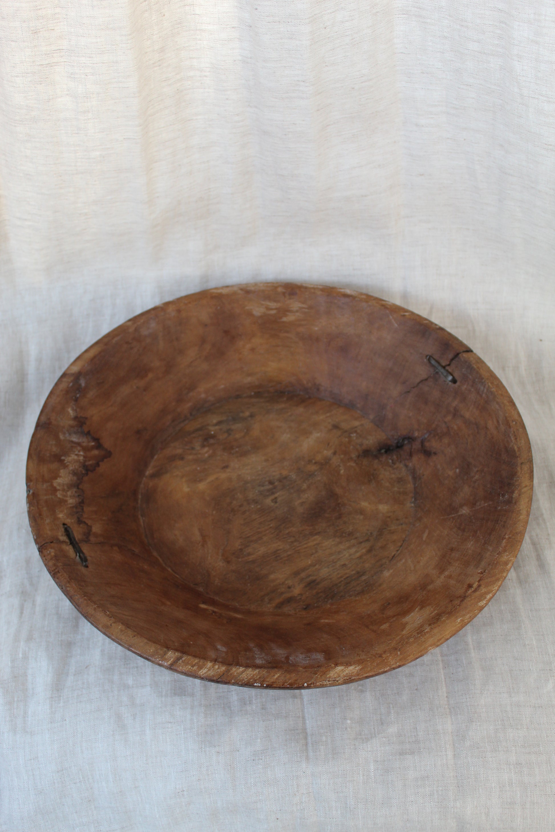 Wooden bowl on a light fabric background