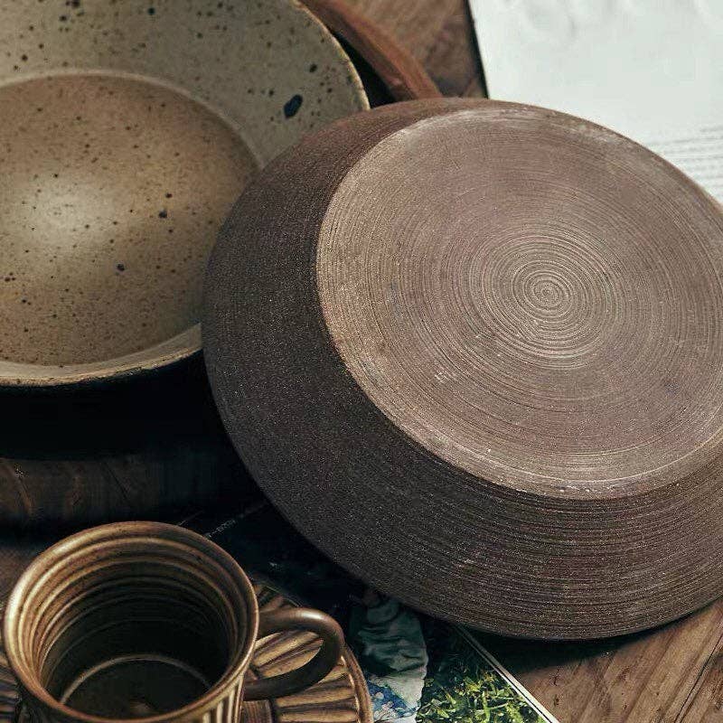Set of ceramic bowls and a mug on a wooden surface
