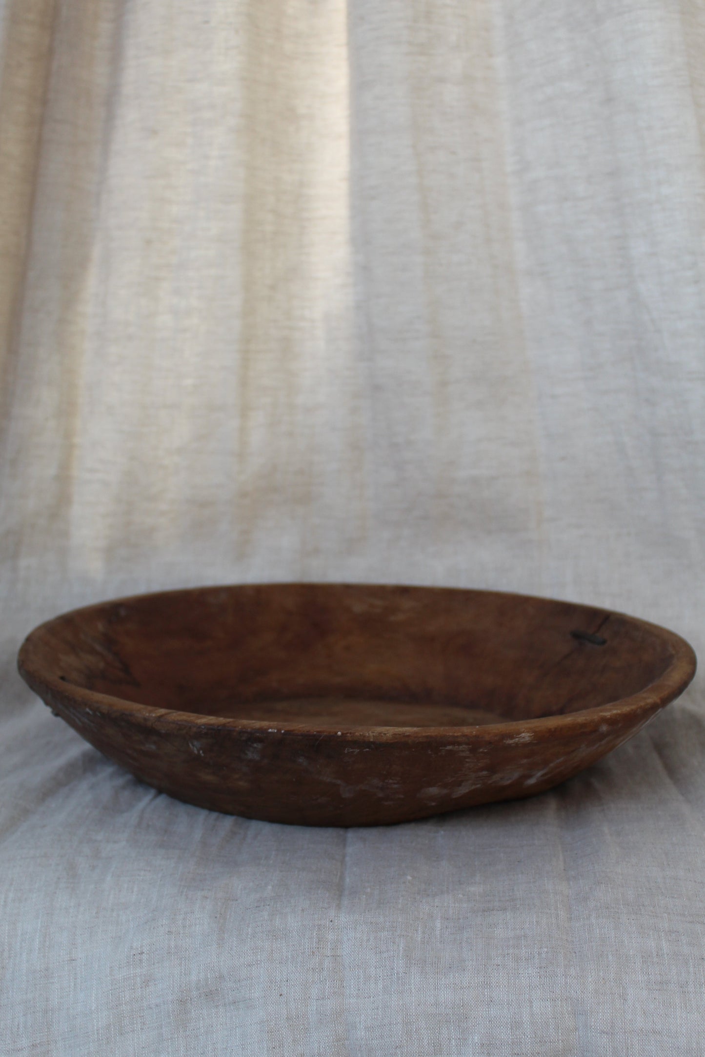 Wooden bowl on a textured fabric background