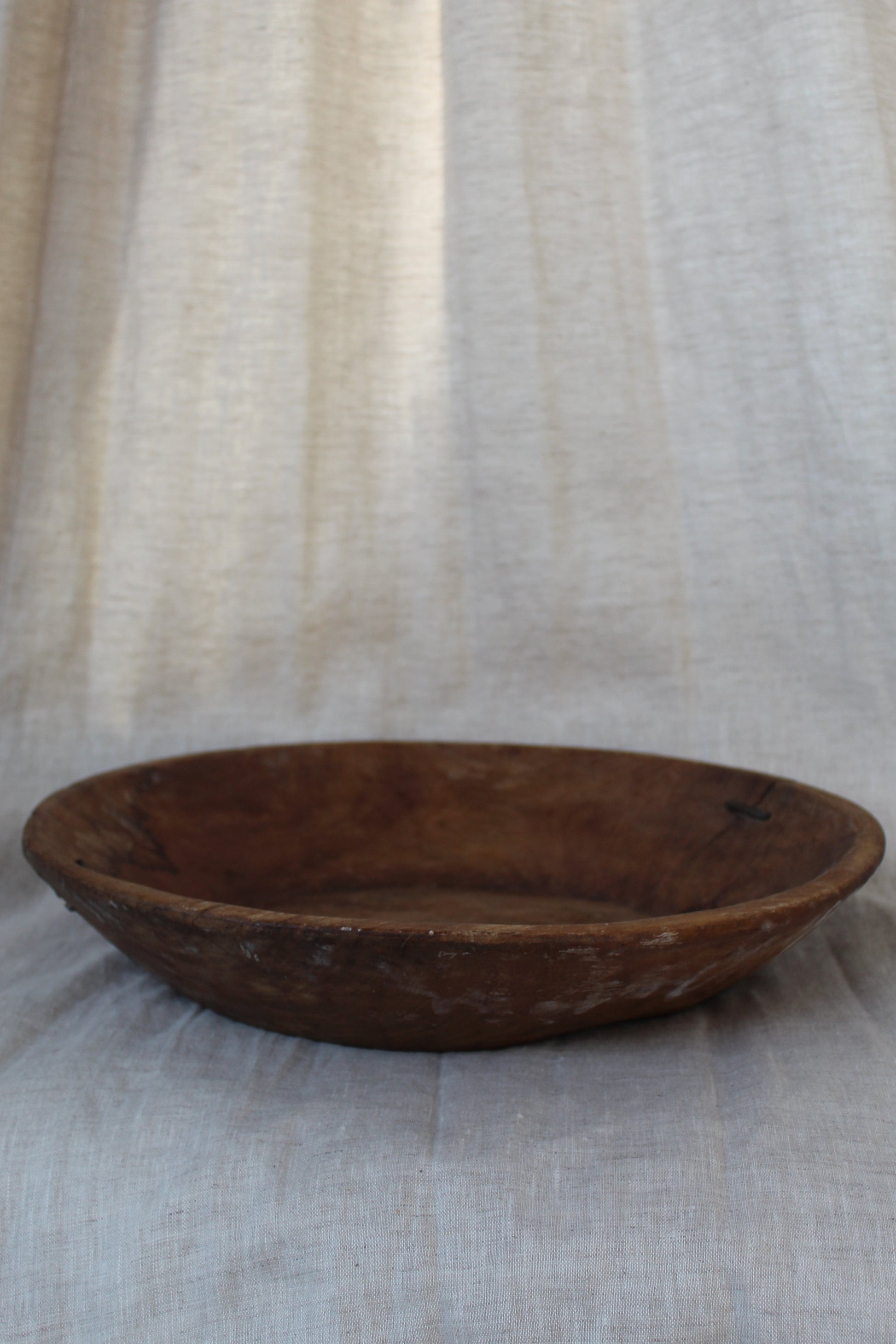 Wooden bowl on a textured fabric background