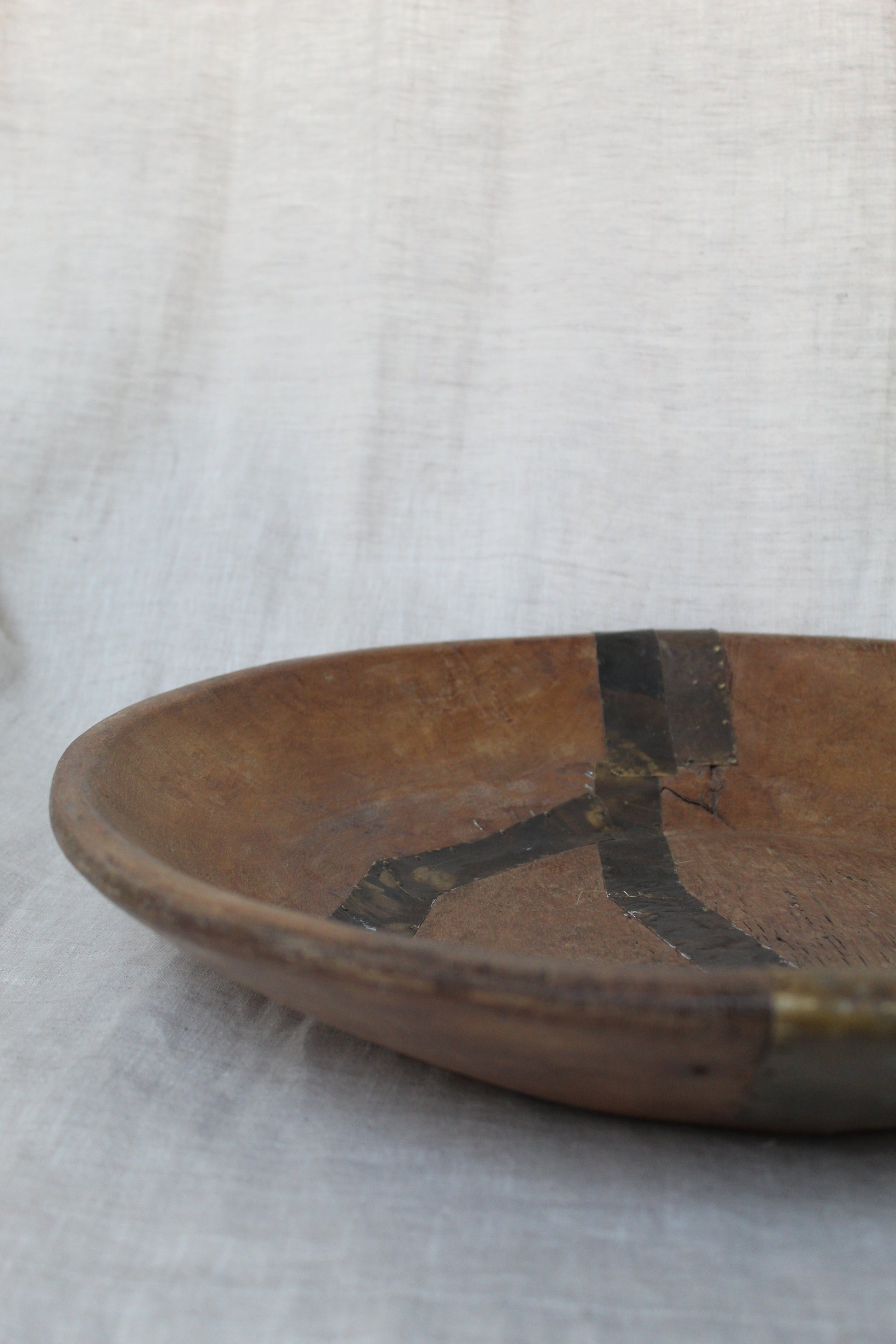 Wooden tool with a metallic tip on a white fabric background