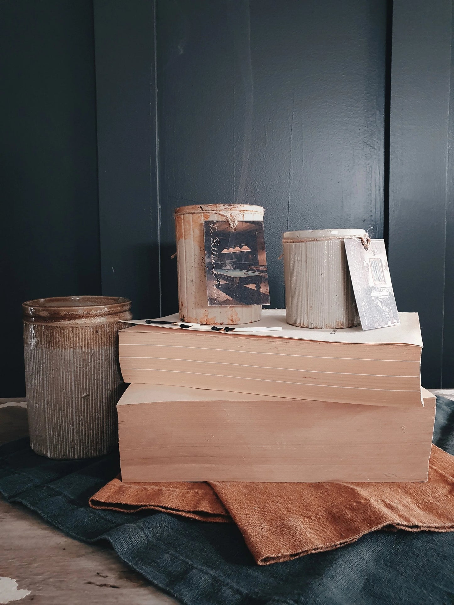 Stack of books with a wooden box on top against a dark wall.