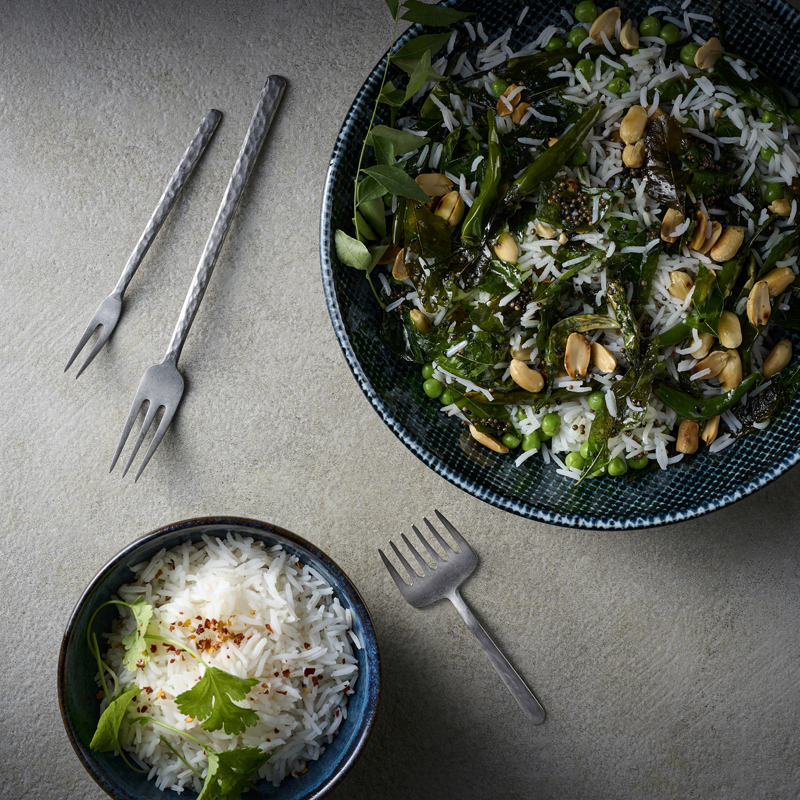 Two bowls of food with forks on a gray surface