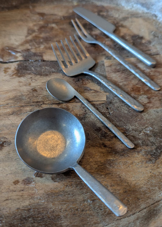 Set of metal kitchen utensils on a wooden surface
