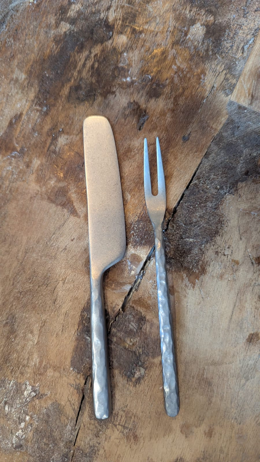 Metal knife and fork on a wooden surface