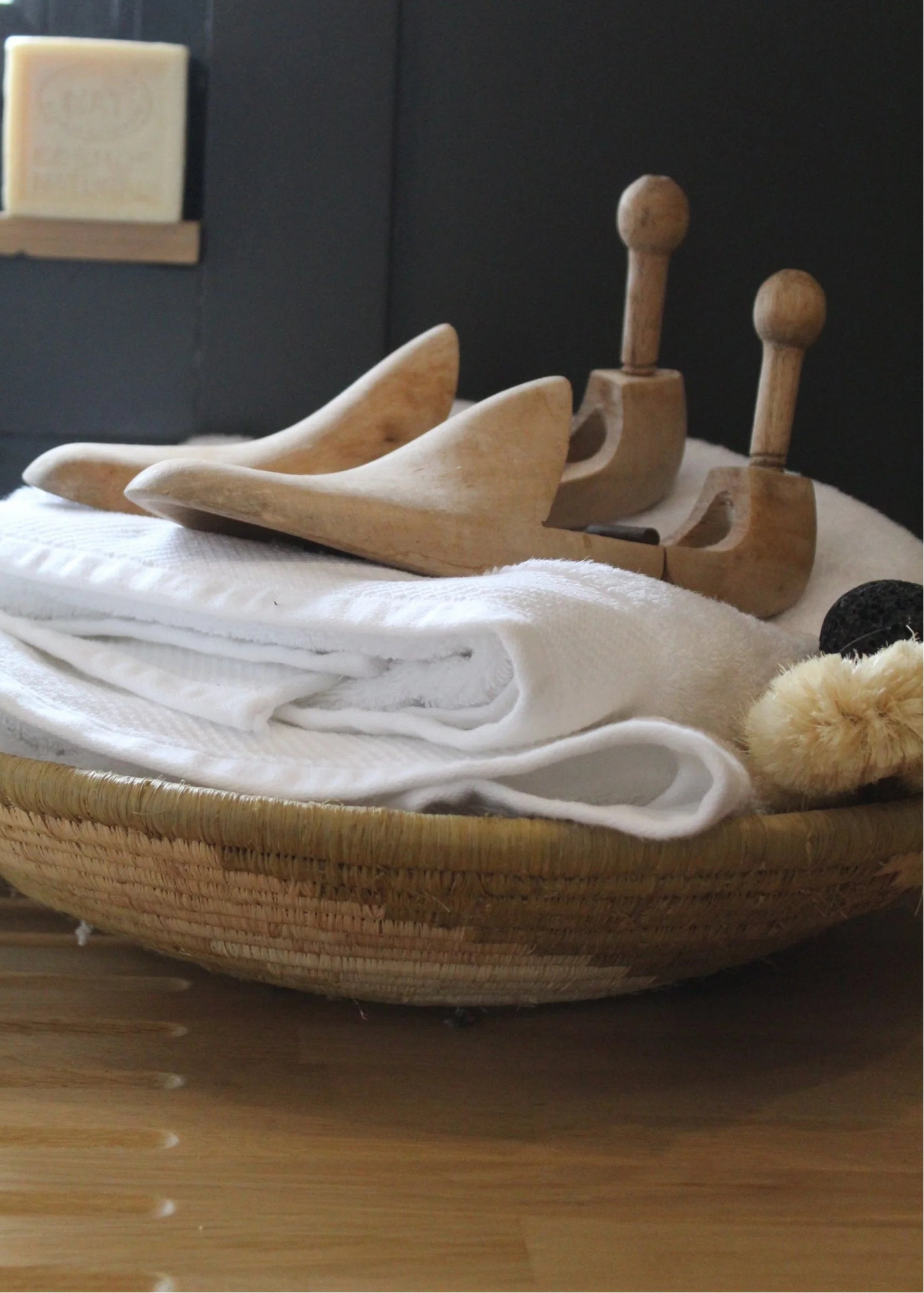 Wooden soap dish with soap and towels on a wooden surface