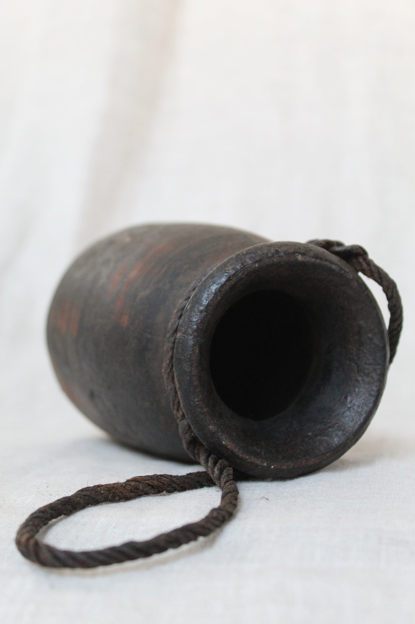 Black leather urn with a rope on a white background