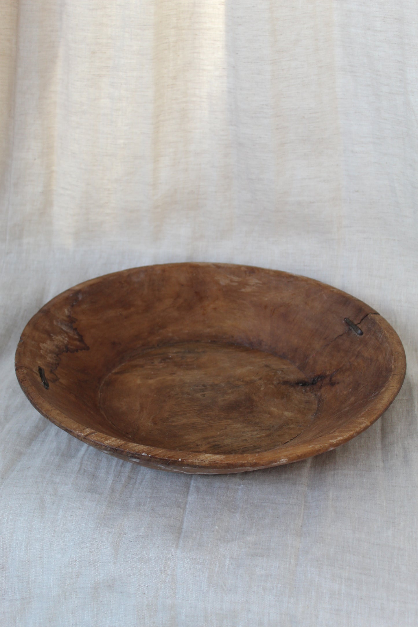 Wooden bowl on a light fabric background